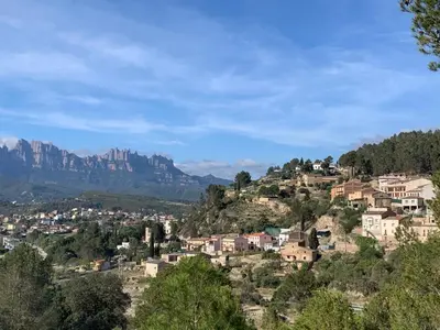 a village on a hill with mountains in the background at Cal General in San Vicente de Castellet
