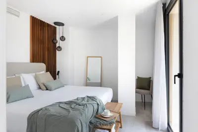 a white bedroom with a bed and a table at master La Rambla in Barcelona