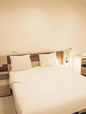 a large bed with white sheets and pillows at Apartamento 15' Barcelona centro in Santa Coloma de Gramanet
