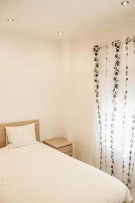 a bedroom with a white bed and a window at Apartamento 15' Barcelona centro in Santa Coloma de Gramanet
