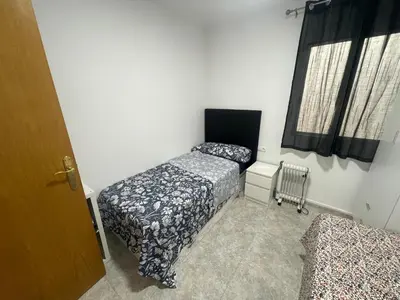 a bedroom with two beds and a window at Apartamentos Atlas Terrassa V in Terrassa