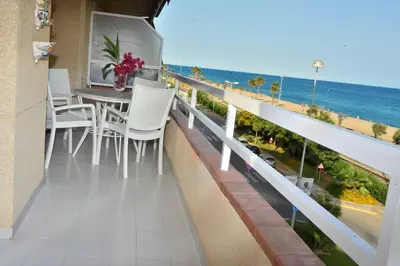 a balcony with a table and chairs and the ocean at New! Fantastic apartament in front of the sea! in Pineda de Mar
