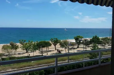 a view of the beach and the ocean from a balcony at New! Fantastic apartament in front of the sea! in Pineda de Mar