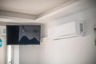 a flat screen tv hanging on a wall at Ático en Calella a 7 minutos de la playa in Calella