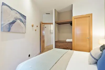 a bedroom with a bed and a wooden door at Click&Flat Gaudi Dream I in Barcelona