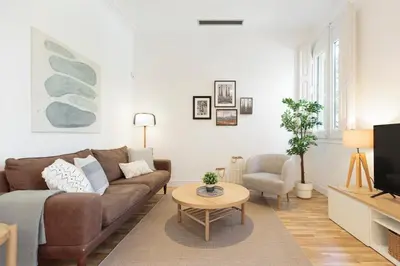 a living room with a brown couch and a table at Click&Flat Gaudi Dream I in Barcelona